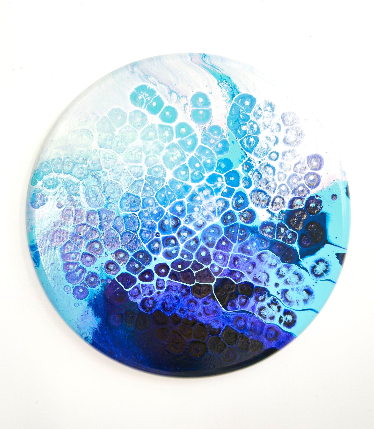 Round blue and white patterned abstract art on a white background