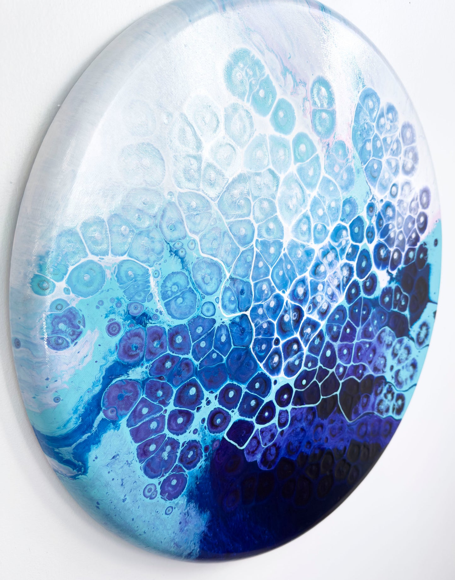 Round abstract art with blue and purple gradient pattern on a white background