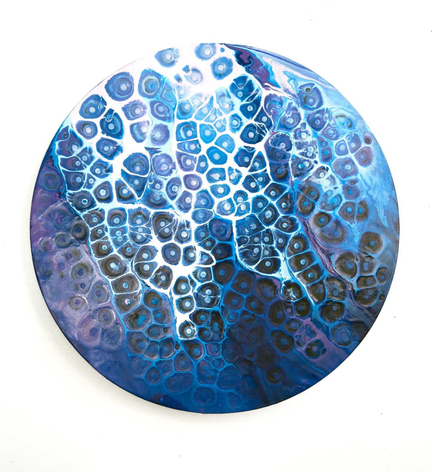 Round blue and white patterned abstract artwork on canvas