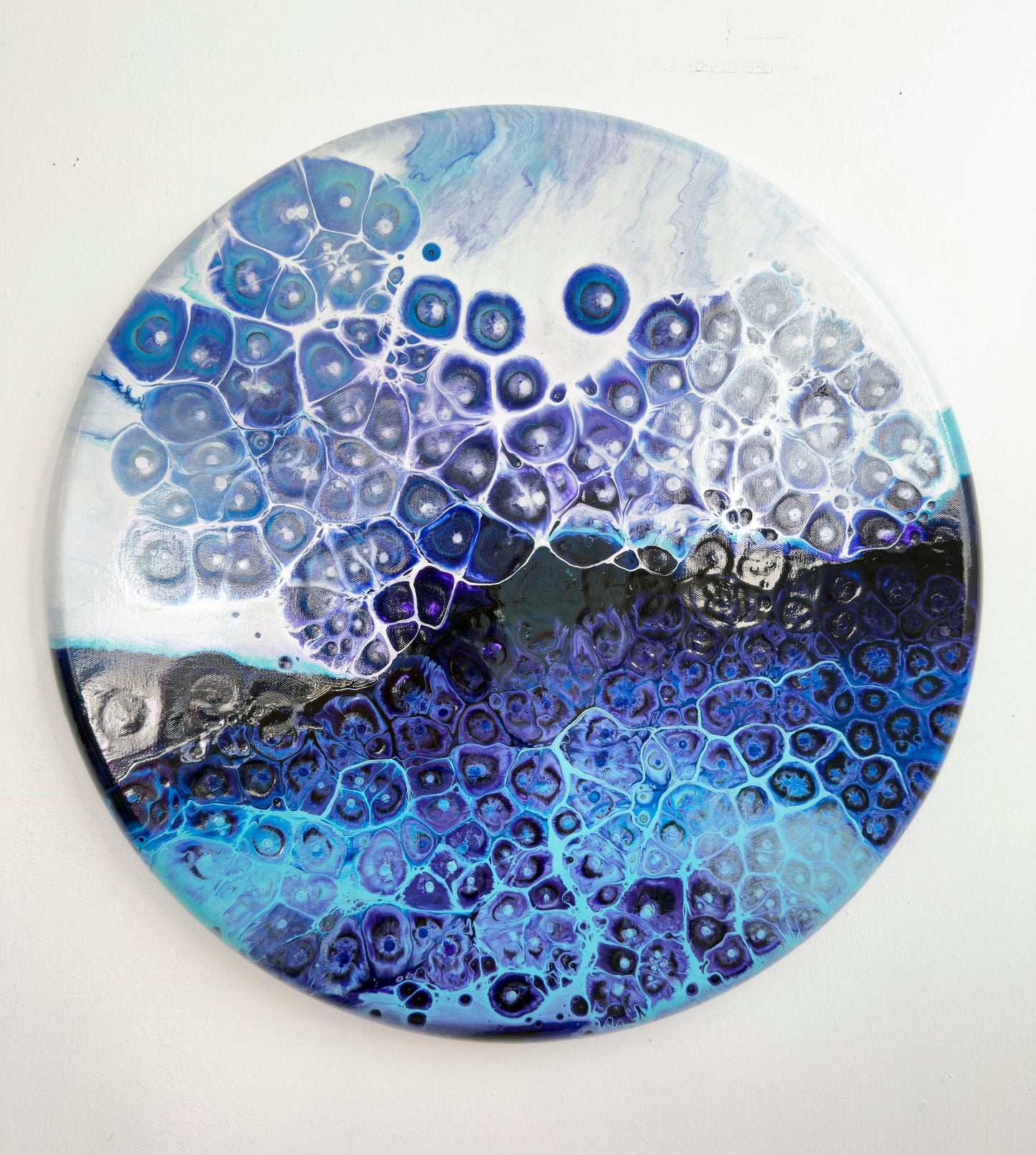 Round decorative abstract art with blue and white pattern on a white background