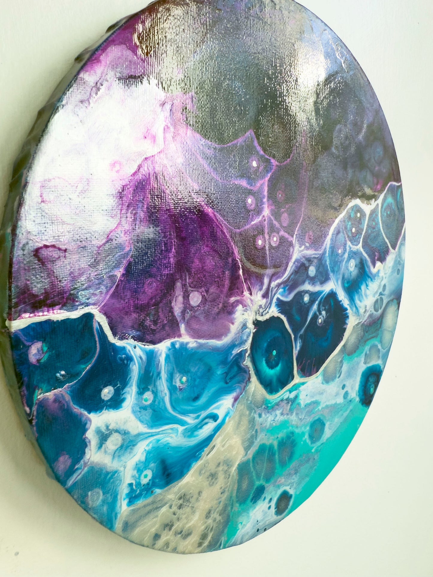 Abstract art piece with purple, blue, and silver colors on a white background
