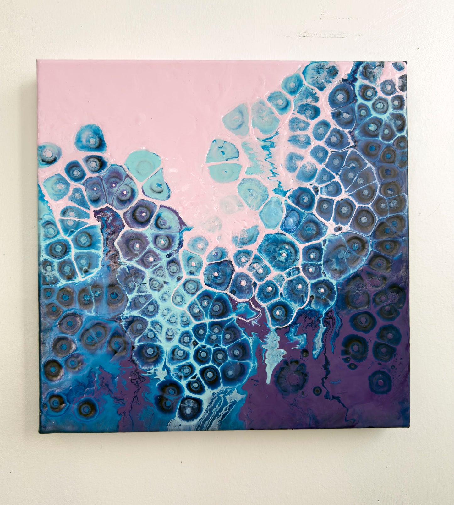 Abstract art piece with blue and purple patterns on a pink background