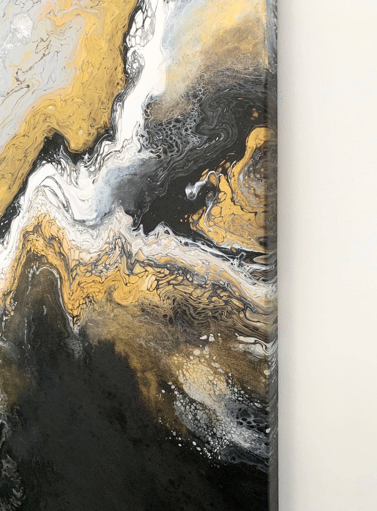 A abstract fluid painting featuring swirls of black, white, and gold colors with a textured and fluid brush stroke technique.